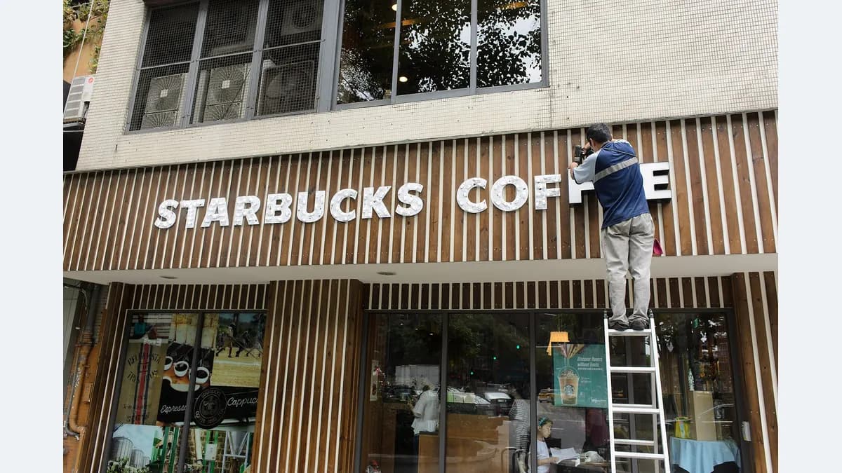Worker on a ladder replacing sign lettering