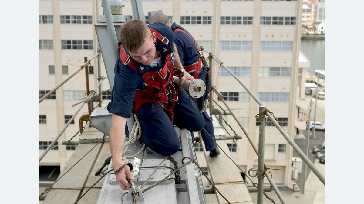 Worker connecting a safety lanyard aboard a ship